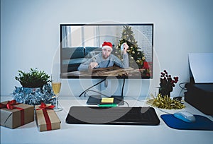 Computer screen with Sad man with face mask home alone on video call missing family at christmas