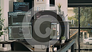 Computer screens on desk running programming code data algorithms