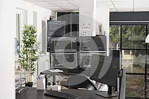 Computer screens display compiling HTML code in unoccupied office