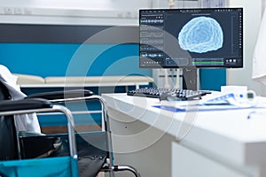 Computer standing on table having brain ct-scan on screen