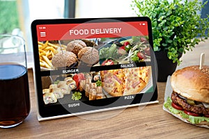 Computer tablet with app food delivery on screen in cafe