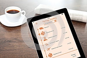 Computer tablet with app tracking delivery package on table