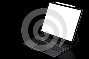 Computer tablet with keyboard and blank screen isolated on black background.