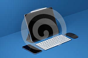 Computer tablet with keyboard, mouse and phone isolated on black background.