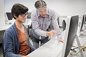 Computer teacher assisting a student