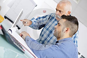 Computer teacher assisting student in classroom