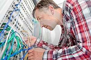 Computer technician checking wiring going to server