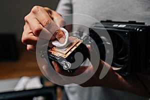 Computer technician cleaning processor cooling system with white cloth, ensuring optimal performance and preventing