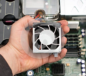 Computer technician holding cooler fan.