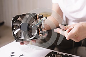 Computer technician installs cooling system of computer. Engineer repairing computer pc board. Technician plug in electronic