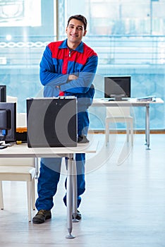 The computer technician repairing broken computer in workshop