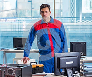 Computer technician repairing broken computer in workshop