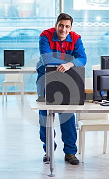 Computer technician repairing broken computer in workshop