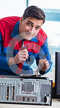 Computer technician repairing broken computer in workshop