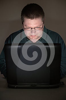 Computer user in darkened room