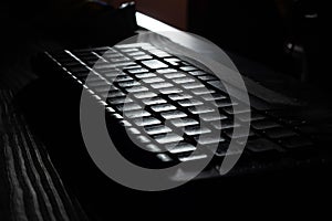 Computer wireless keyboard on wooden table background on the office in moonlight