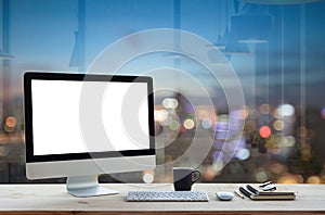 Computer on work table and city night background