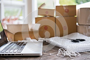 computer at workplace of start up, small business owner, freelance, entrepreneur, SME seller. cardboard parcel box of product for