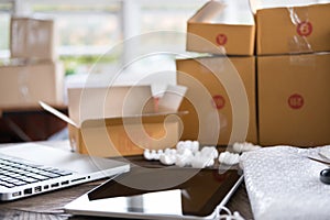 computer at workplace of start up, small business owner, freelance, entrepreneur, SME seller. cardboard parcel box of product for