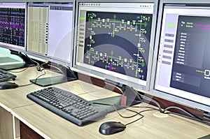 Computers and monitors with schematic diagram for supervisory, control and data acquisition photo