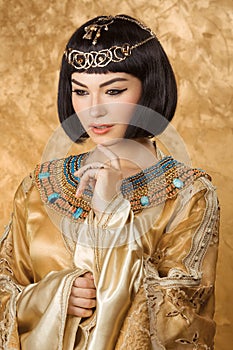 Conceived Beautiful woman like Egyptian Queen Cleopatra on golden background