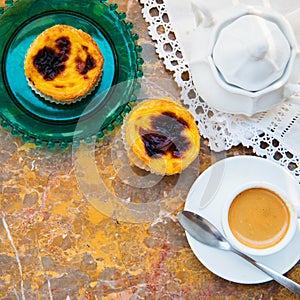 Conceived with the morning coffee and cakes Pasteis de nata, typical pastry from Portugal on natural marble surface.