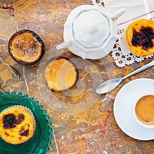 Conceived with the morning coffee and cakes Pasteis de nata, typical pastry from Portugal on natural marble surface.