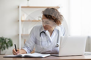 Concentered young female general practitioner involved in paperwork.