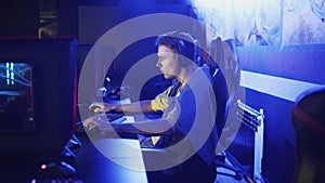 Concentraited man Playing in Online Video Game in modern e-sport cybersport club