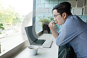 Concentrate Asian businessman with eyeglasses working with smart