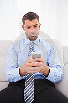 Concentrate man using his phone at home