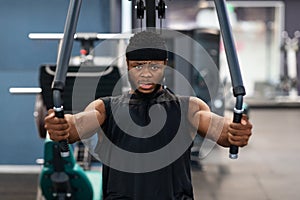 Concentrated african american man exercising on pec deck machine