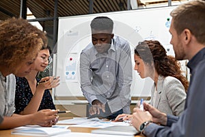 Concentrated african american team leader discussing results with colleagues.