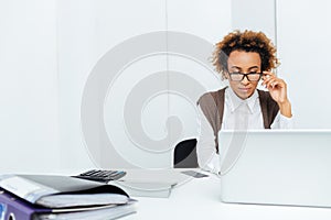 Concentrated african american woman accountant working in office using laptop