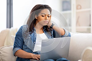 Concentrated african american woman working on laptop