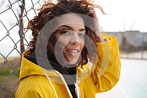 Concentrated african curly young lady wearing yellow coat