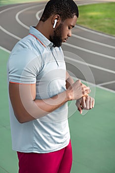 Concentrated athletic man looking at his fitness tracker