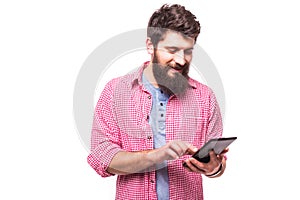 Concentrated bearded hipster man with digital tablet