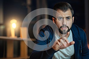 Concentrated bearded man pointing at computer