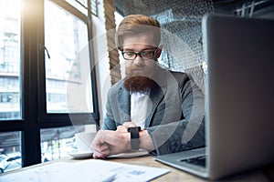 Concentrated bearded man sitting at the table