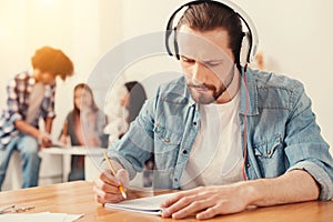 Concentrated bearded man writing a test