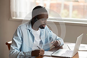 Concentrated biracial man in earphones study on laptop