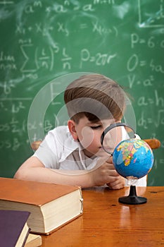 Concentrated boy examines globe