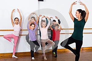 Concentrated boys and girls rehearsing ballet dance in studio