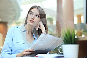 Concentrated business lady comparing documents at office.