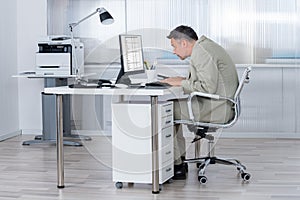 Concentrated Businessman Using Computer At Desk