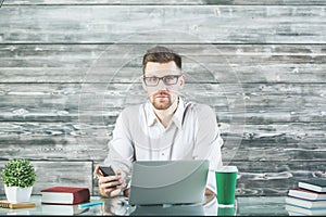 Concentrated businessman using device at workplace