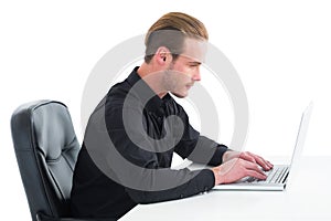 Concentrated businessman using laptop at desk
