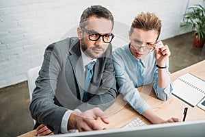 concentrated businesspeople working with computer together