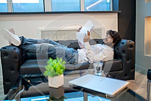 Concentrated businessperson perusing documents in his office